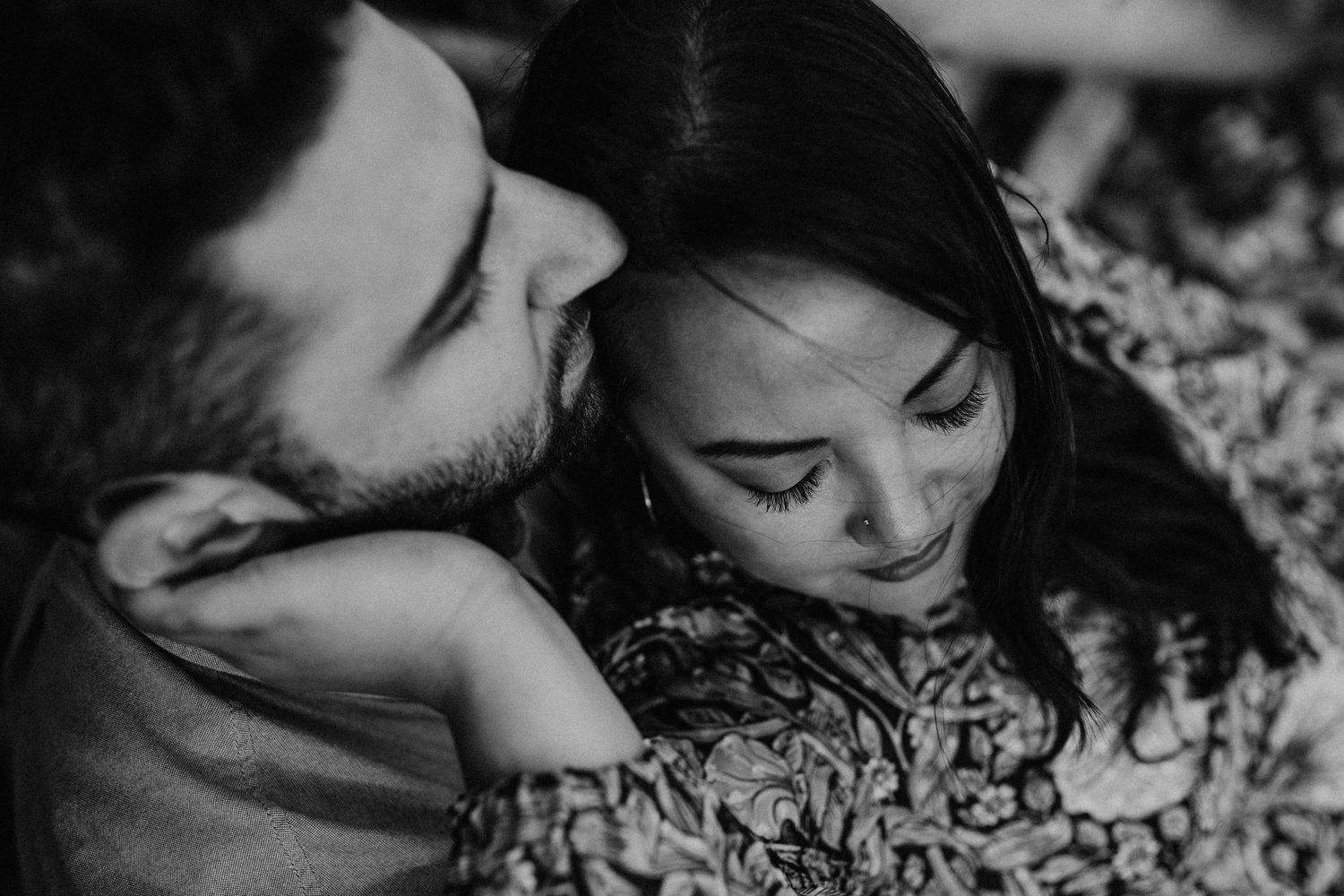 A romantic black and white close-up portrait showing tender intimacy between a couple.