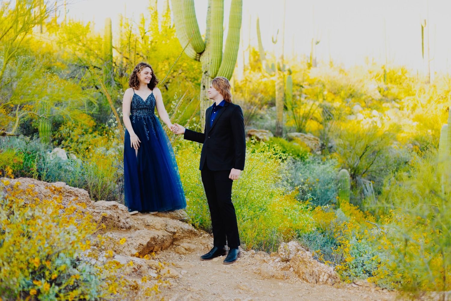A formal photo session in a desert garden with vibrant yellow wildflowers.