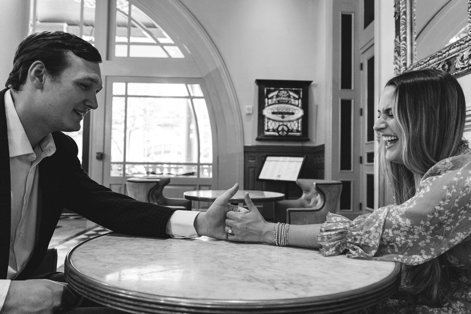 Black and white photo of two people having conversation at retro diner table.