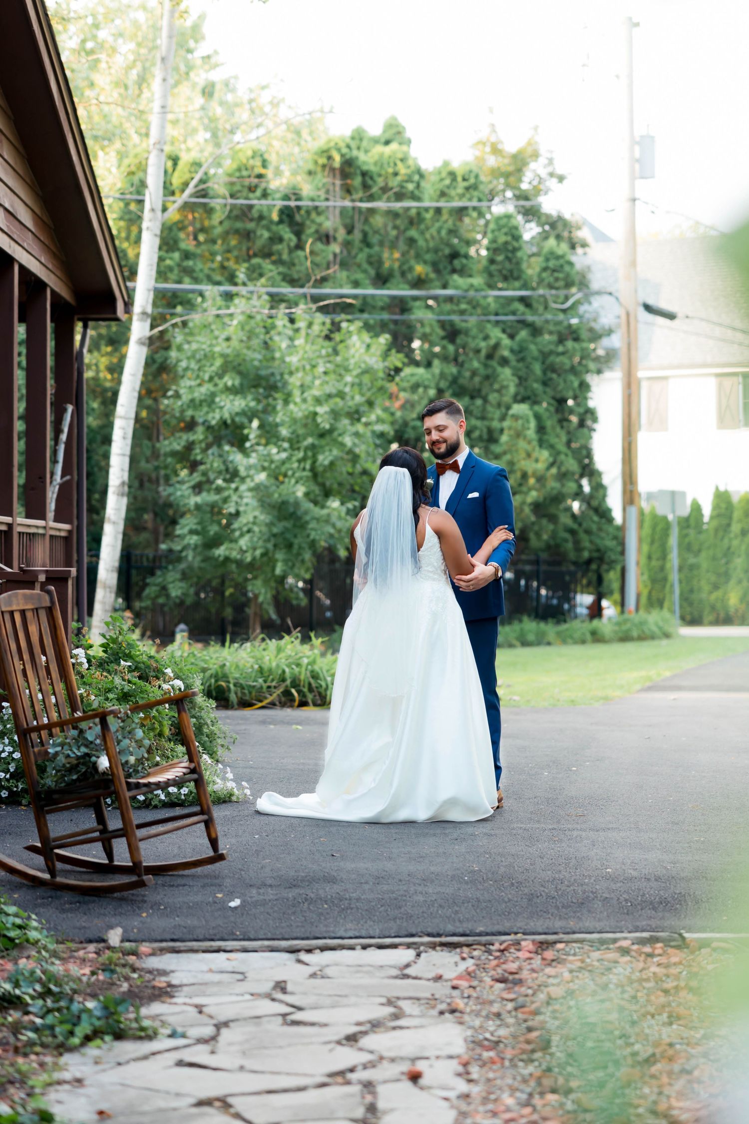 Wedding photo series on rustic porch with rocking chairs and flowing white dress.