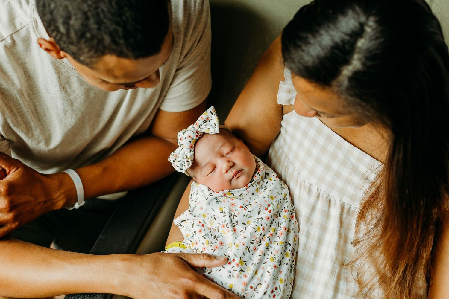 Family bonding with newborn baby wearing floral print clothing.