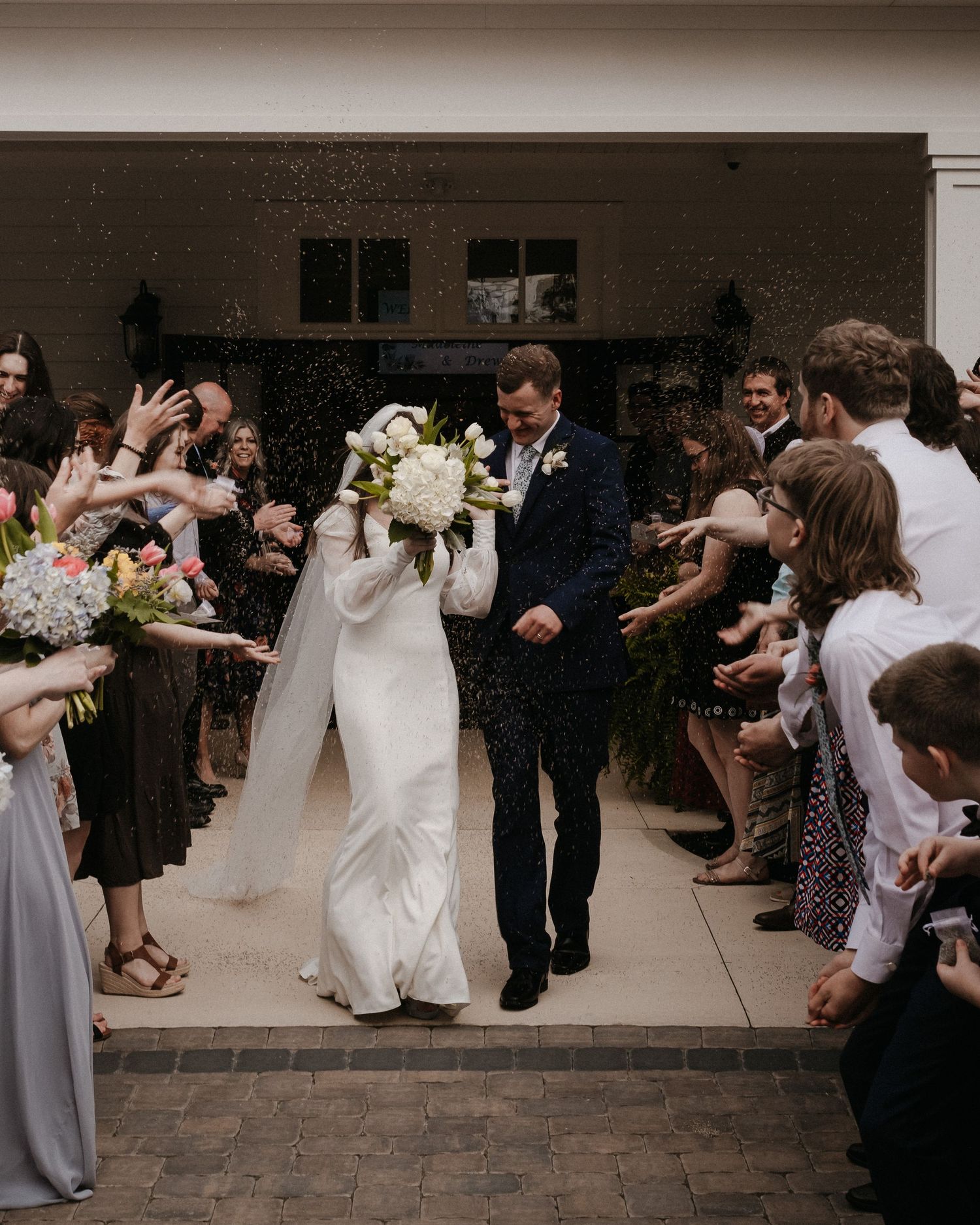 Wedding guests forming a celebratory exit line outside a venue.