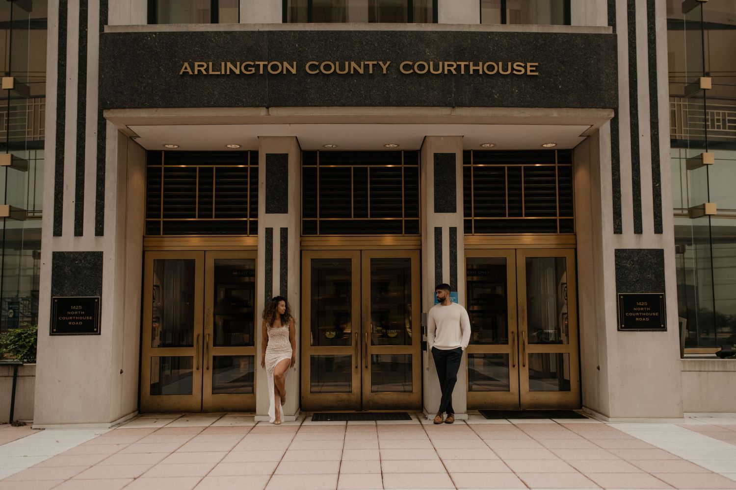 Front entrance of Arlington County Courthouse with two people standing at the doors.