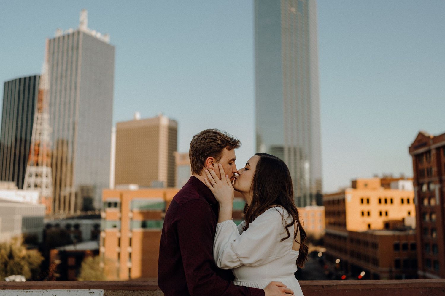 Romantic moment shared against urban cityscape with skyscrapers in background.