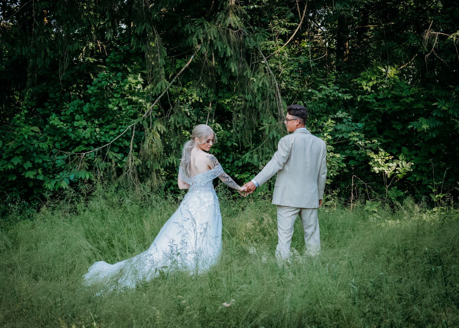 Newlyweds walking through wooded area for portrait session on wedding day
