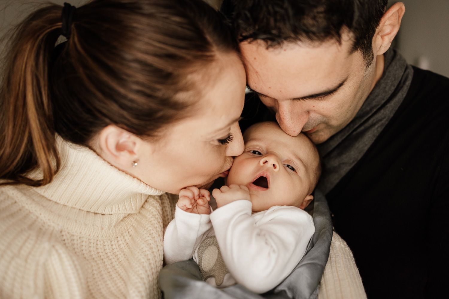 Parents kiss baby's head during newborn session in San Jose by Newborn Photographer Cindy Tucey