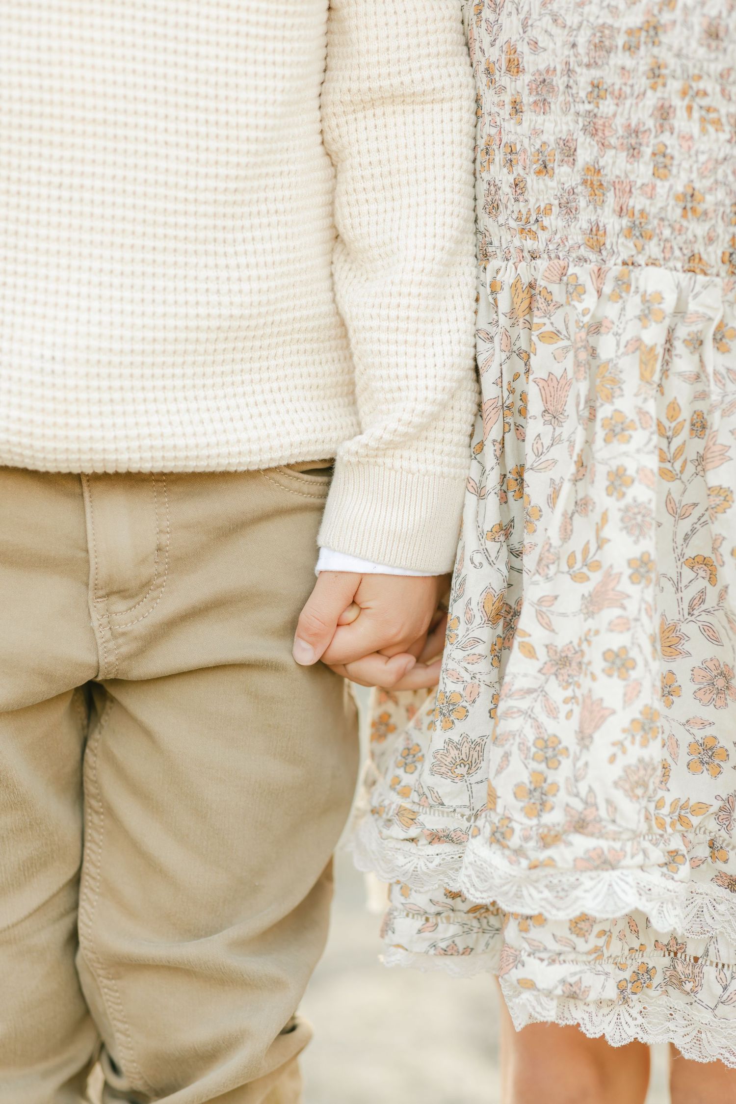 Close-up detail of clothing featuring cream knit and floral fabric patterns captured by Chelsee Rawe Photography