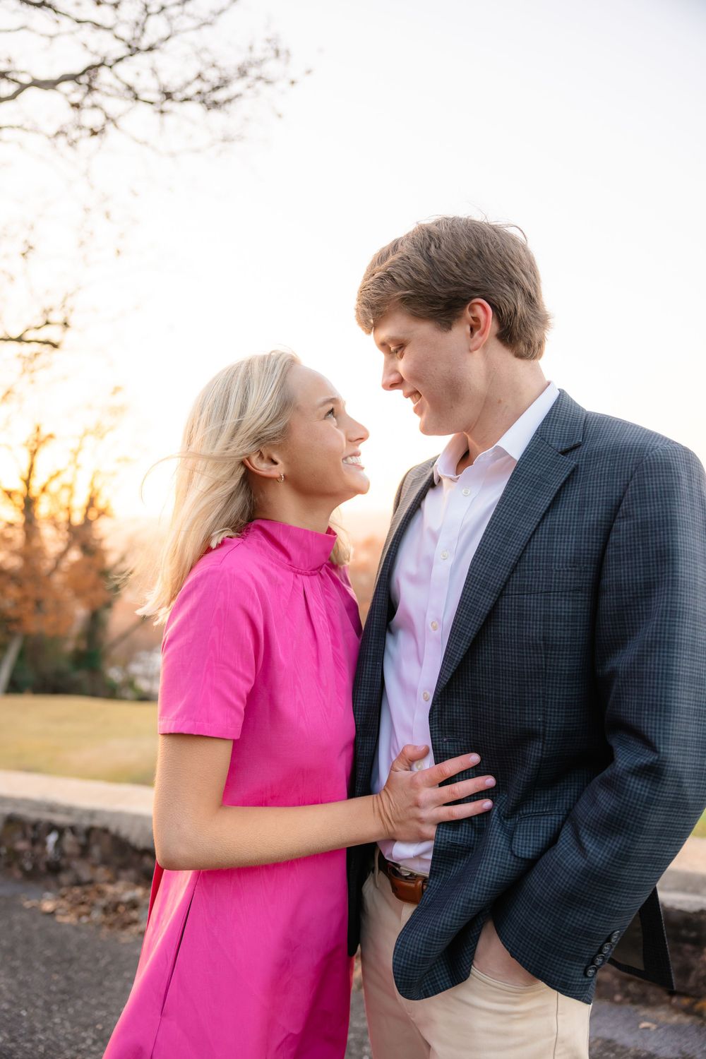 Couple smiling at each other outdoors at golden hour sunset.
