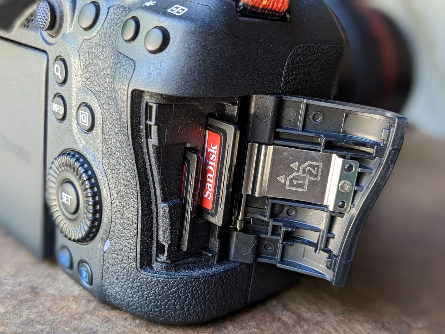 Close up of camera memory card slot and compartment door.