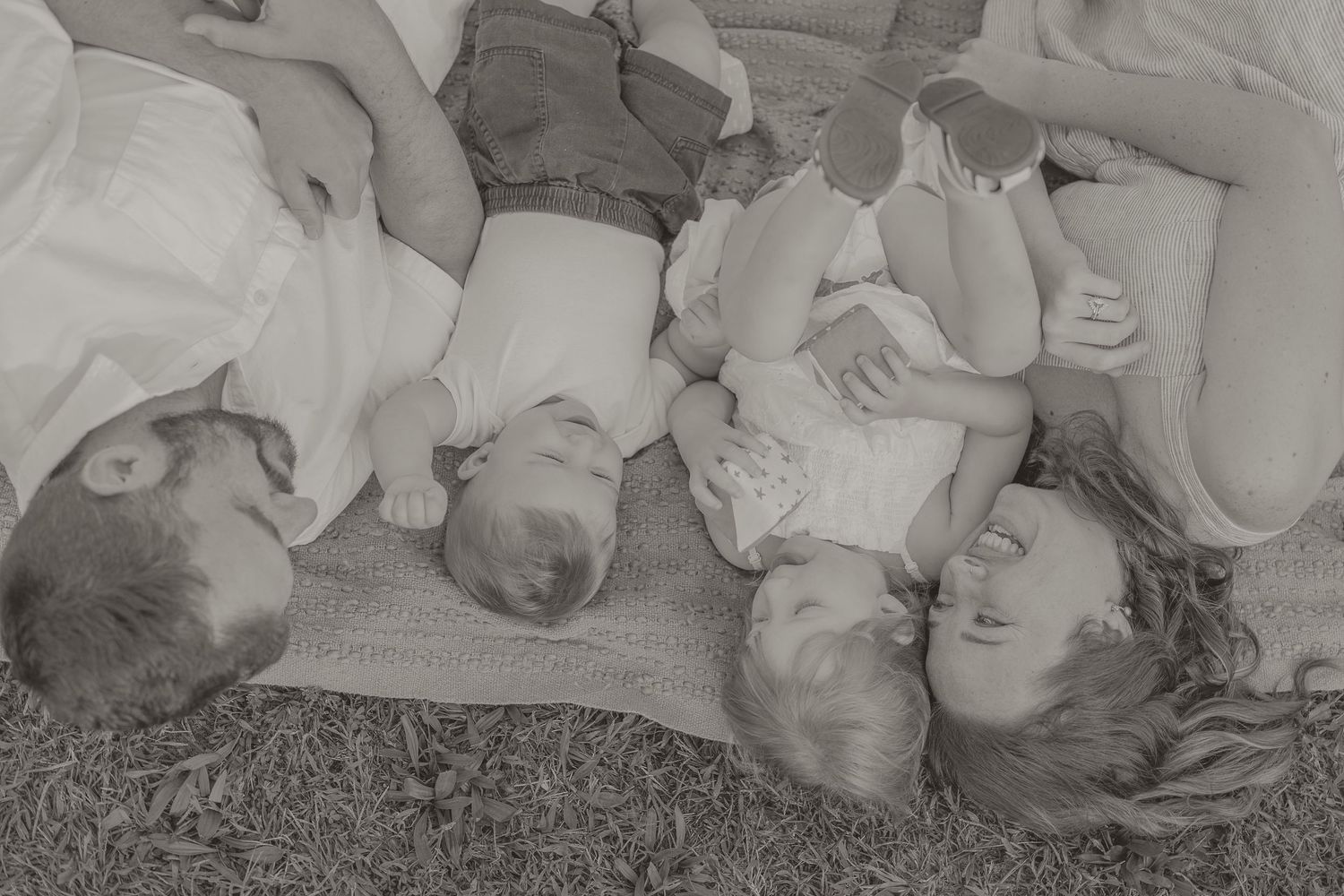 Black and white photo series showing a sleeping baby in different positions on a soft surface.