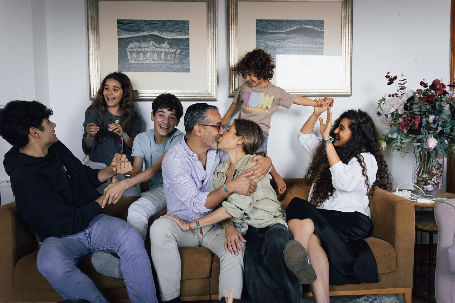 Motion blur captures a playful group moment on a couch with people in dynamic poses and casual attire.