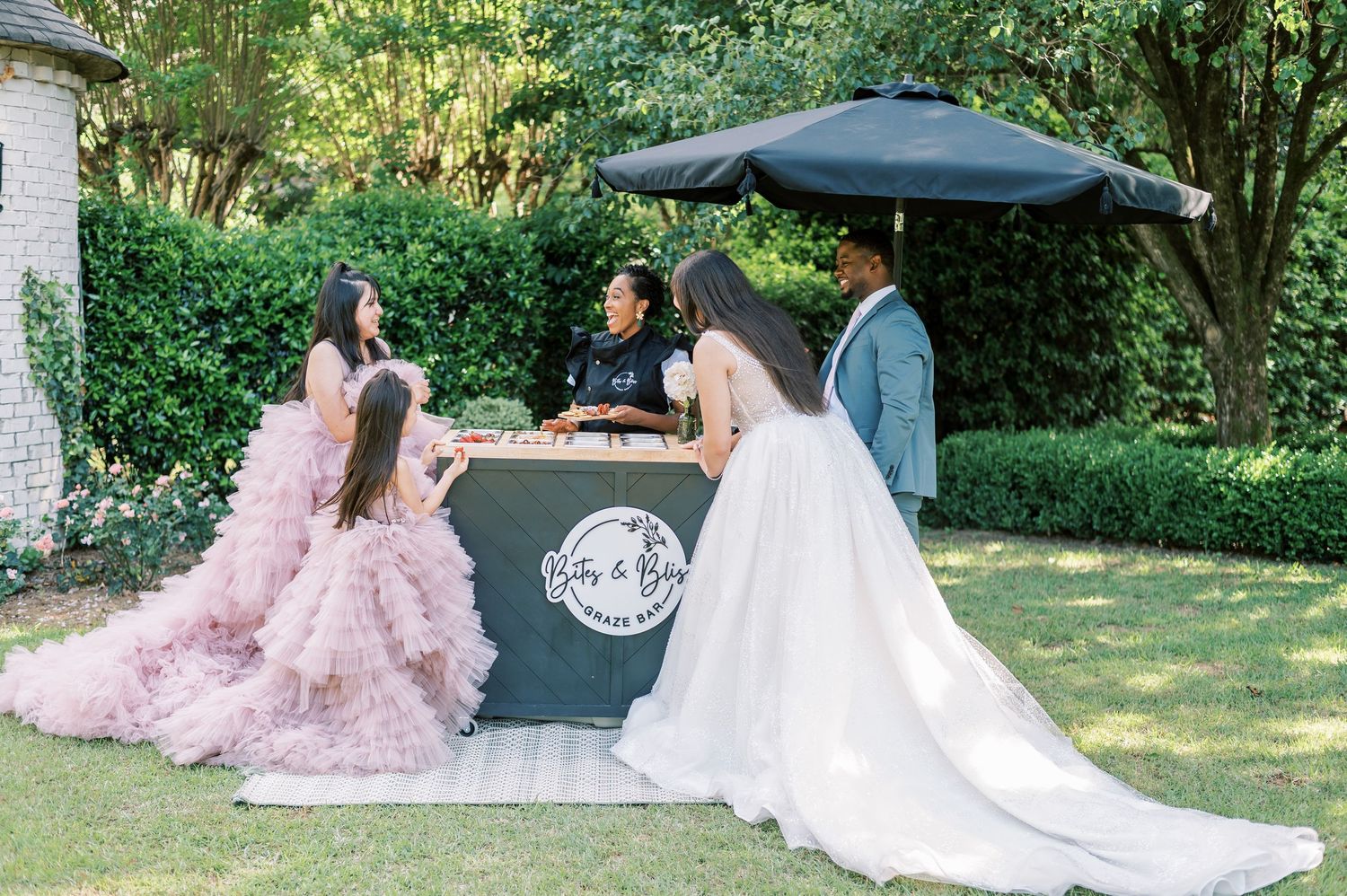 A smoky outdoor barbecue grill with white wedding dresses visible in an outdoor garden setting.