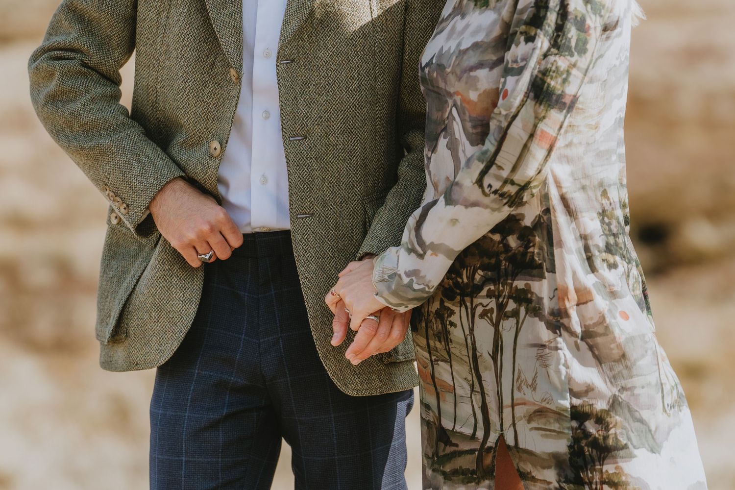 A couple stands together on a mountain trail overlooking a scenic valley during a hike in nature.