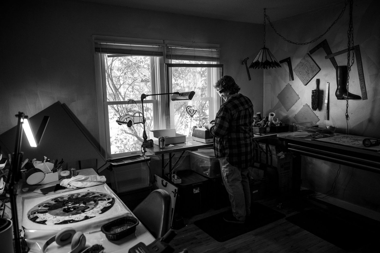 Black and white photographs show a cluttered workshop space with tools and equipment scattered throughout.