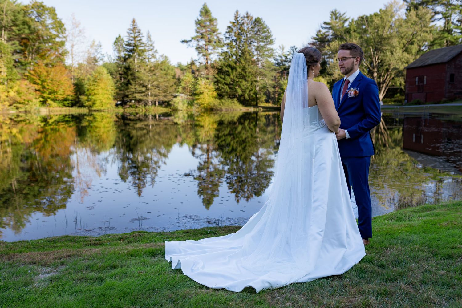Wedding ceremony takes place under a rustic wooden pavilion with exposed beams and scenic view through archway in background.