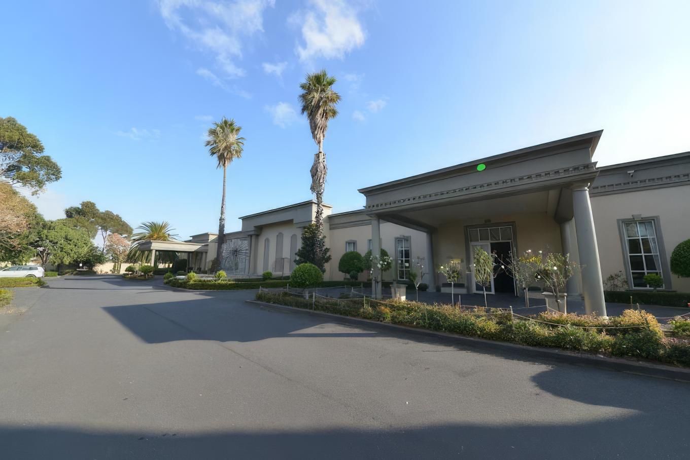 A series of connected commercial buildings with palm trees and parking lots visible in an office park complex.