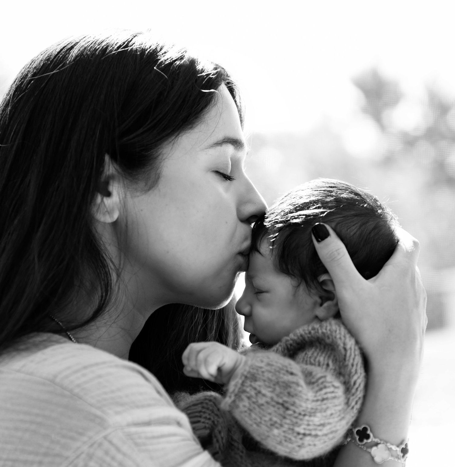 Black and white photo of mother kissing her baby