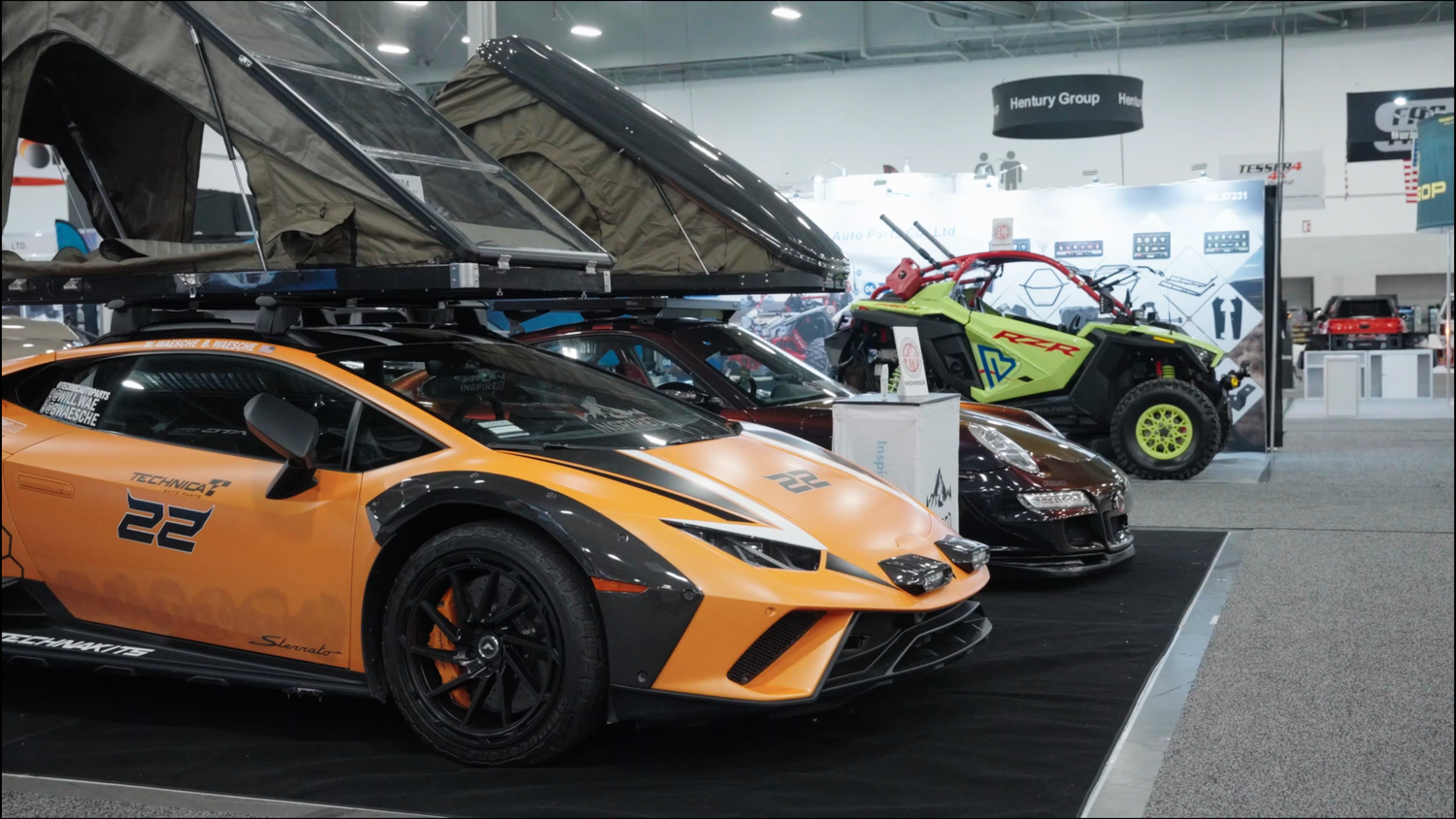 Row of luxury sports cars including Lamborghinis and McLarens on display in a bright indoor showroom.