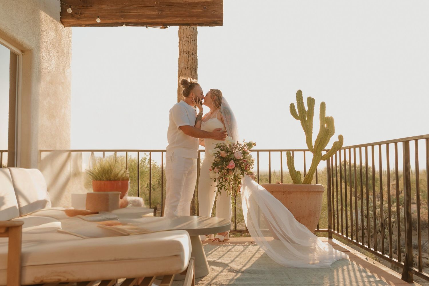 Romantic couples embrace on an outdoor terrace overlooking a scenic mountain landscape at sunset.
