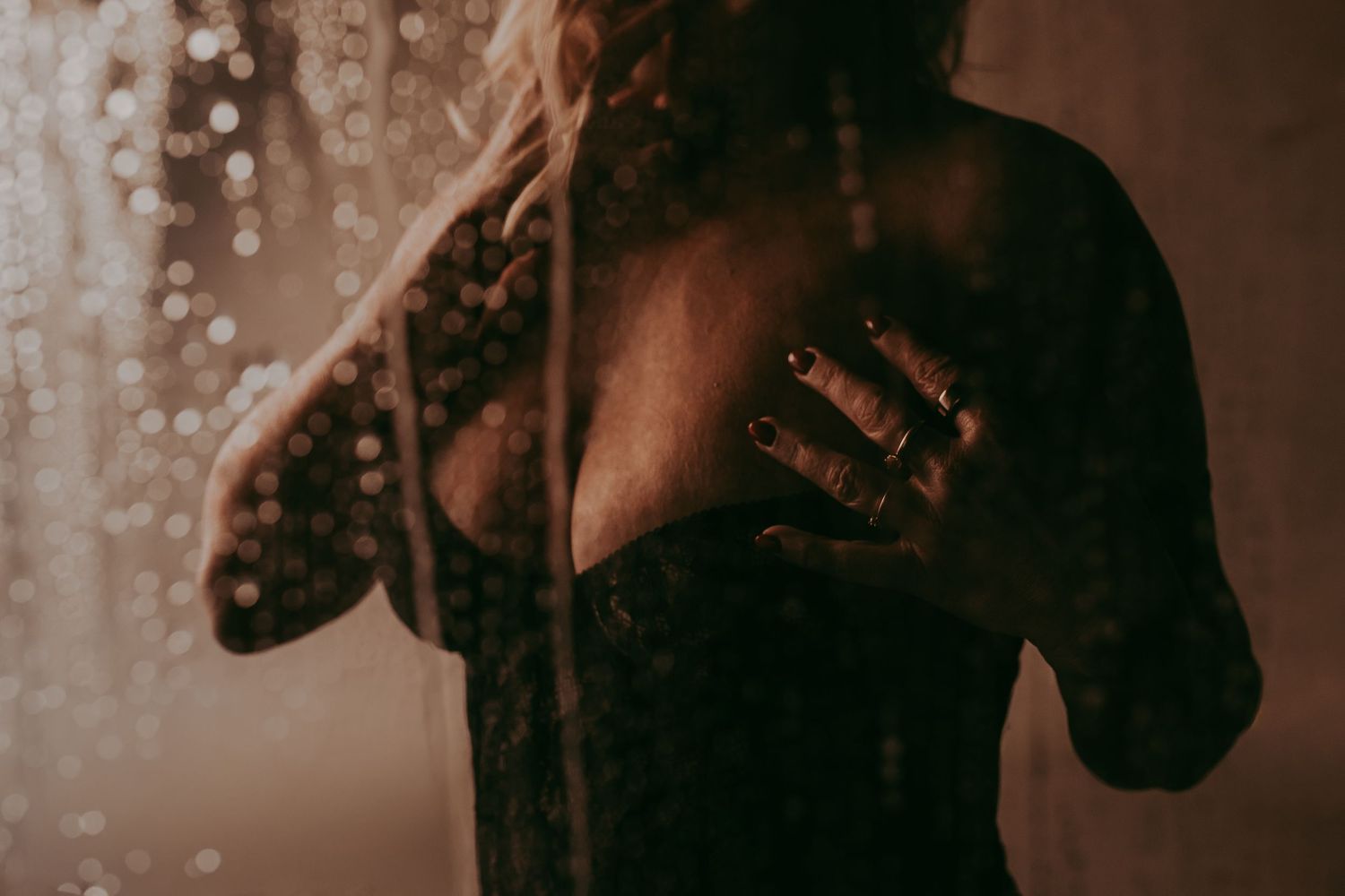 Vrouw met zwarte lingerie die zichzelf mooi vasthoudt en druppels op het scherm