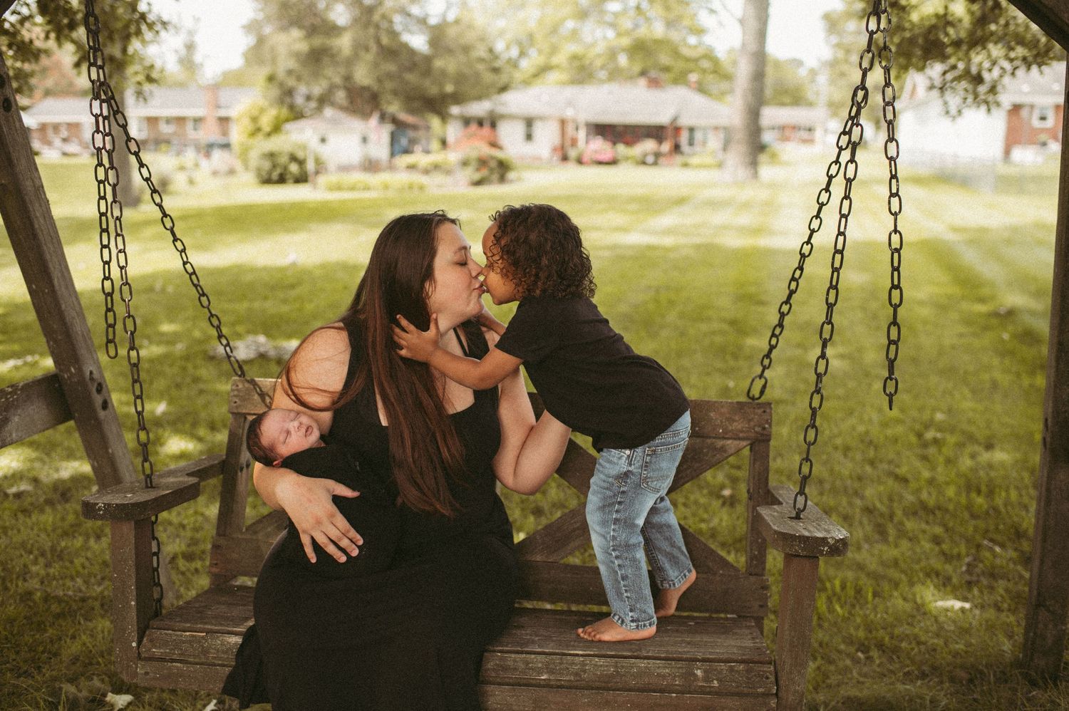 Mom of two giving her first born a smooch in their Suffolk, VA backyard.