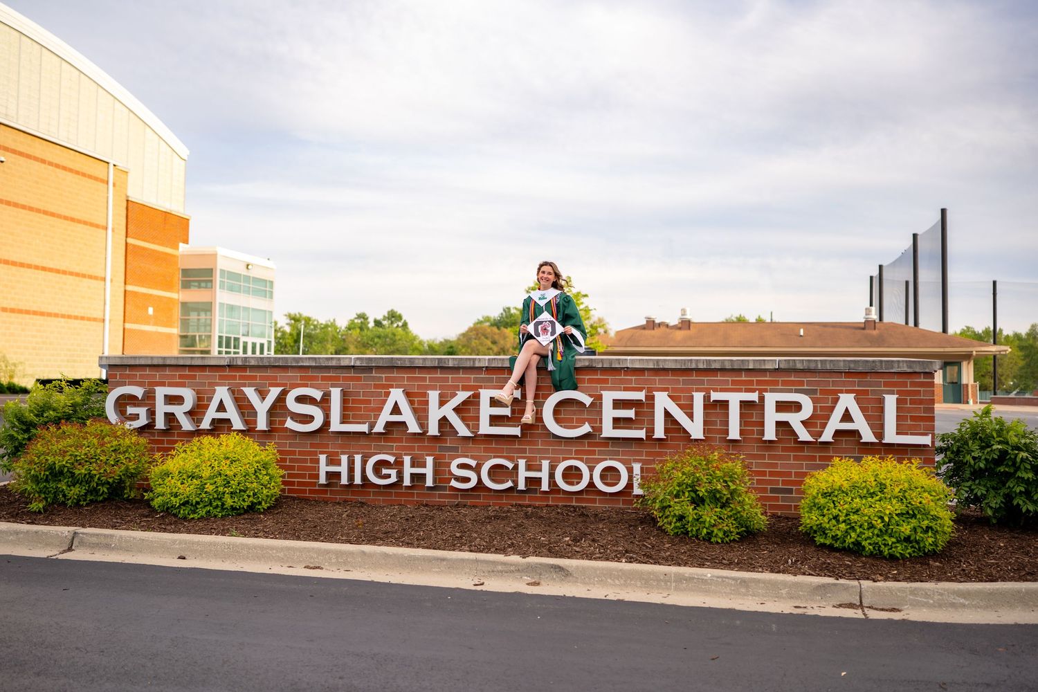 Exterior view of Grayslake Central High School entrance with signage and brick facade on a cloudy day.