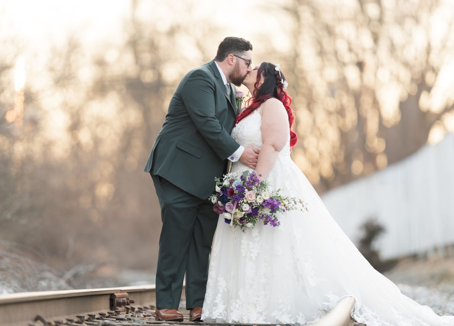 Bride and groom kissing on the train tracks during Kristen and Mat's Mendenhall Inn wedding portraits.