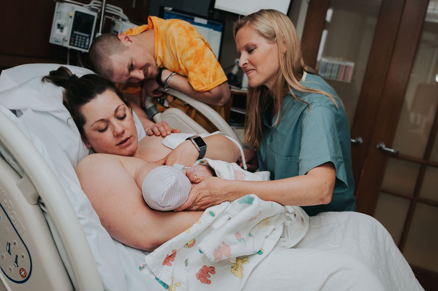 A midwife helps her client breastfeed her newborn shortly after birth at CHI St. Elizabeth in Lincoln, NE. Photo by Novita Birth Stories.