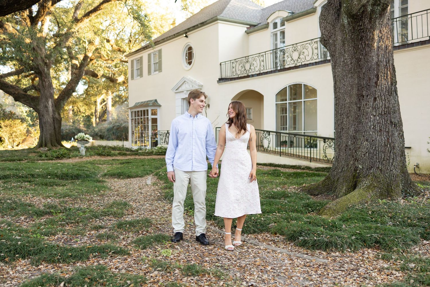 A bridal portrait in front of a grand white columned plantation house with sweeping lawn.