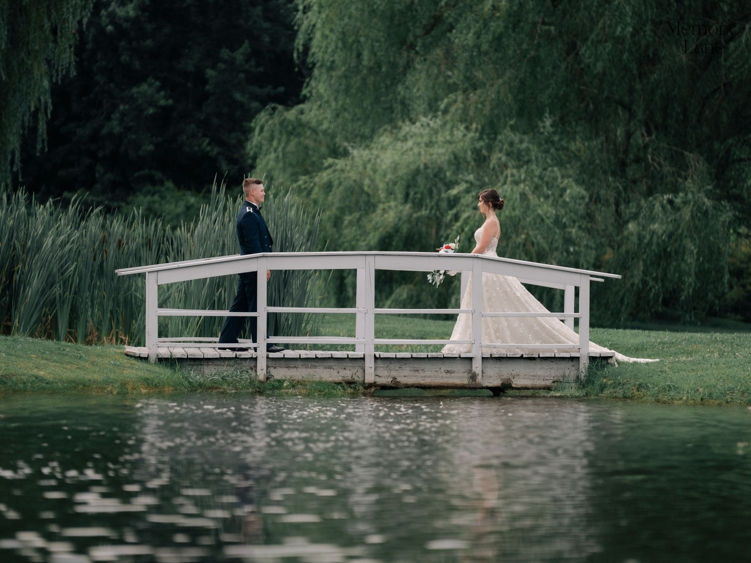 Romantic scene on a wooden bridge over a pond surrounded by willow trees.