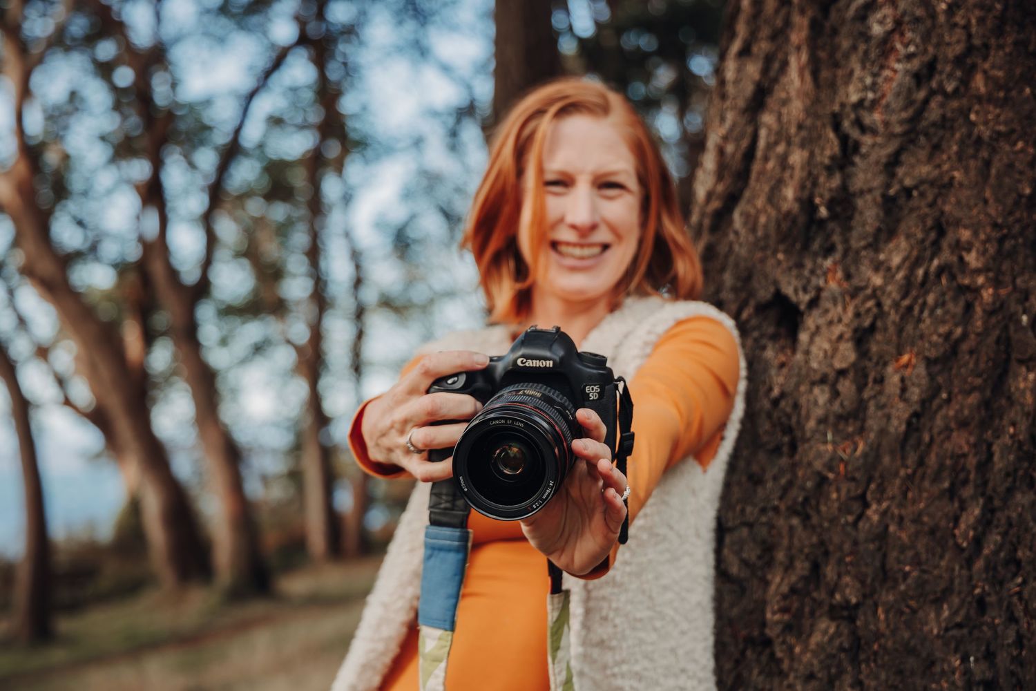 Camera against autumn trees showing photography setup.