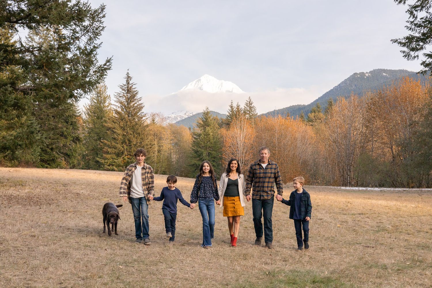 Family holding hands and smiling in photography by Aquilina Larkins Olson