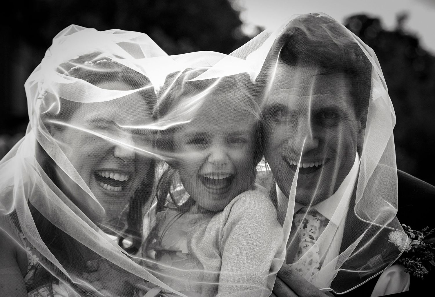 Black and white photo with flowing veil creating artistic effect.