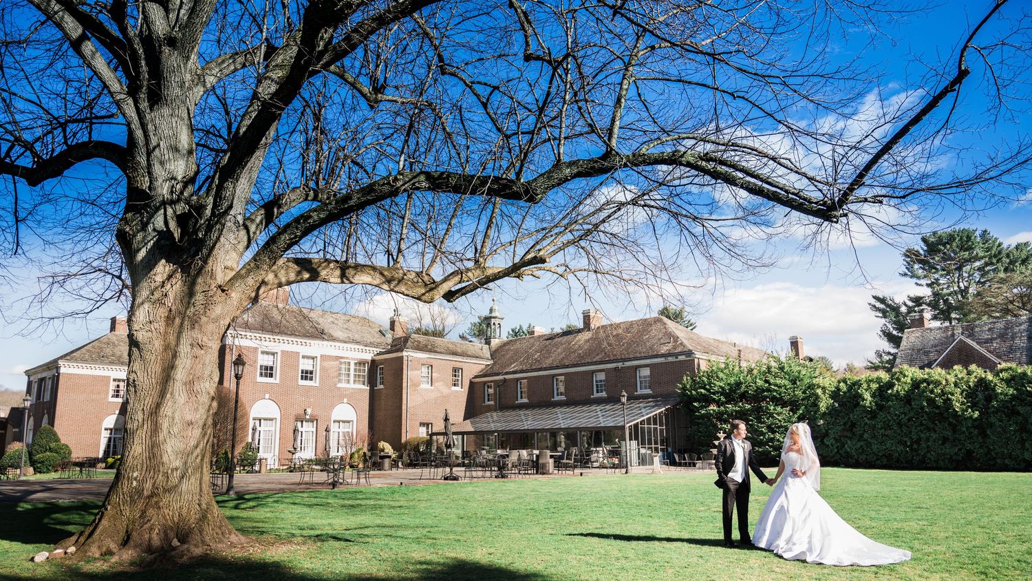 A couple holding hands in front of the NYIT Mansion. Long Island Wedding Photographers