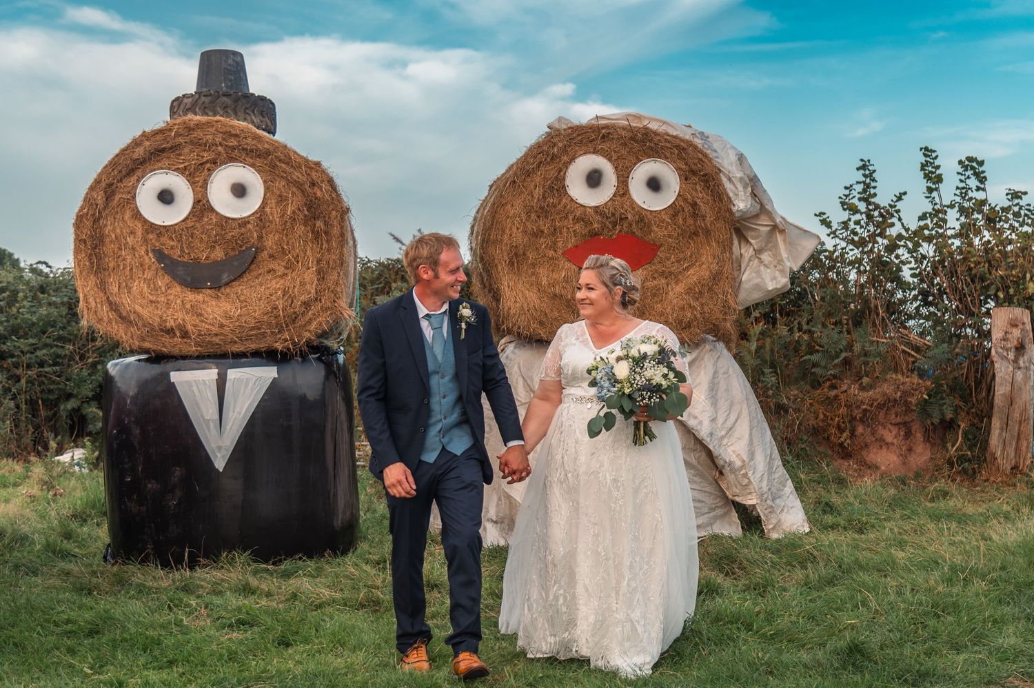 Whimsical wedding photos with large hay bale decorations featuring painted cartoon faces.