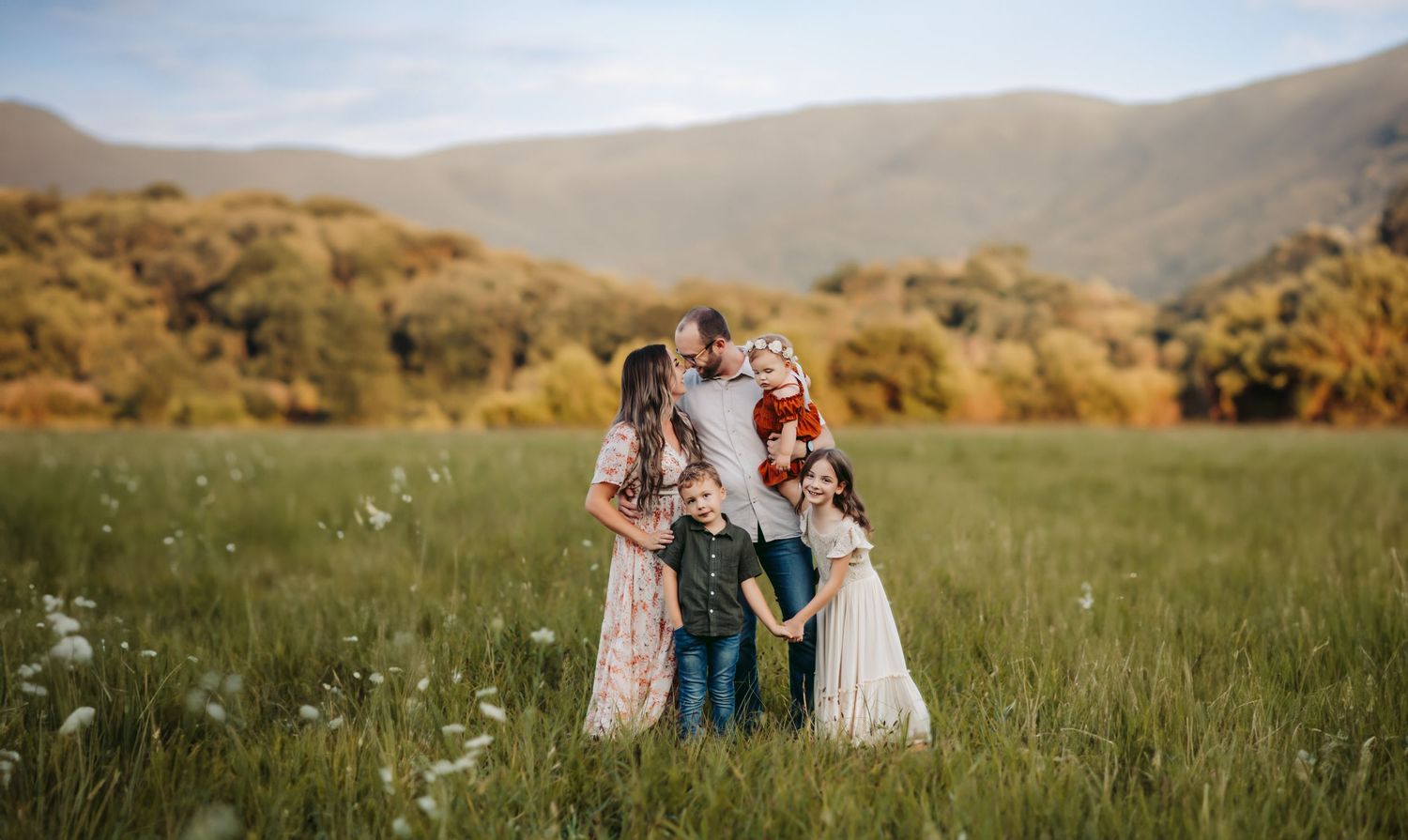 Family of five smiling and holding hands during photoshoot in the Smoky Mountains
