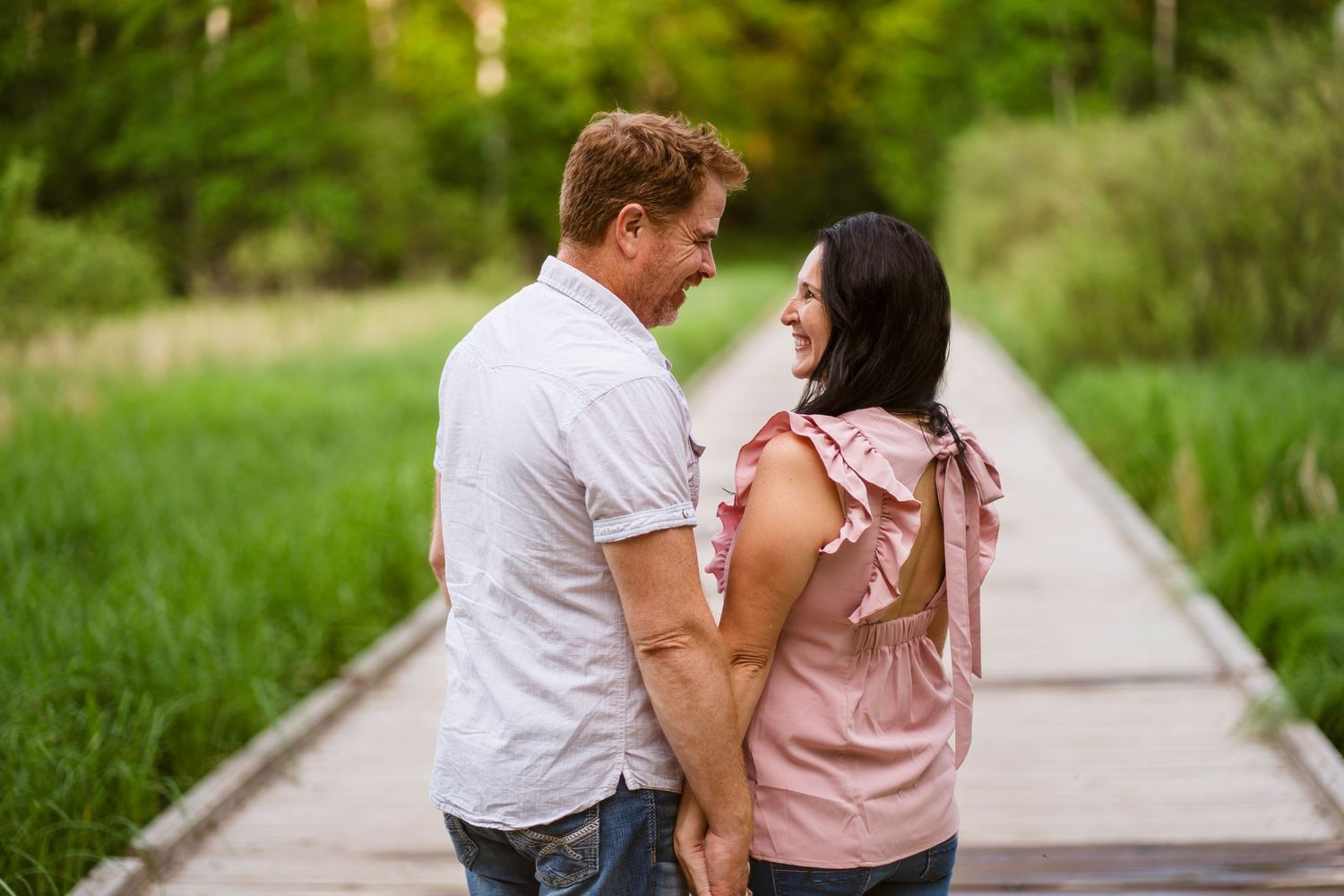 Couple smiles at each other on a floating bridge at Quarry Park
