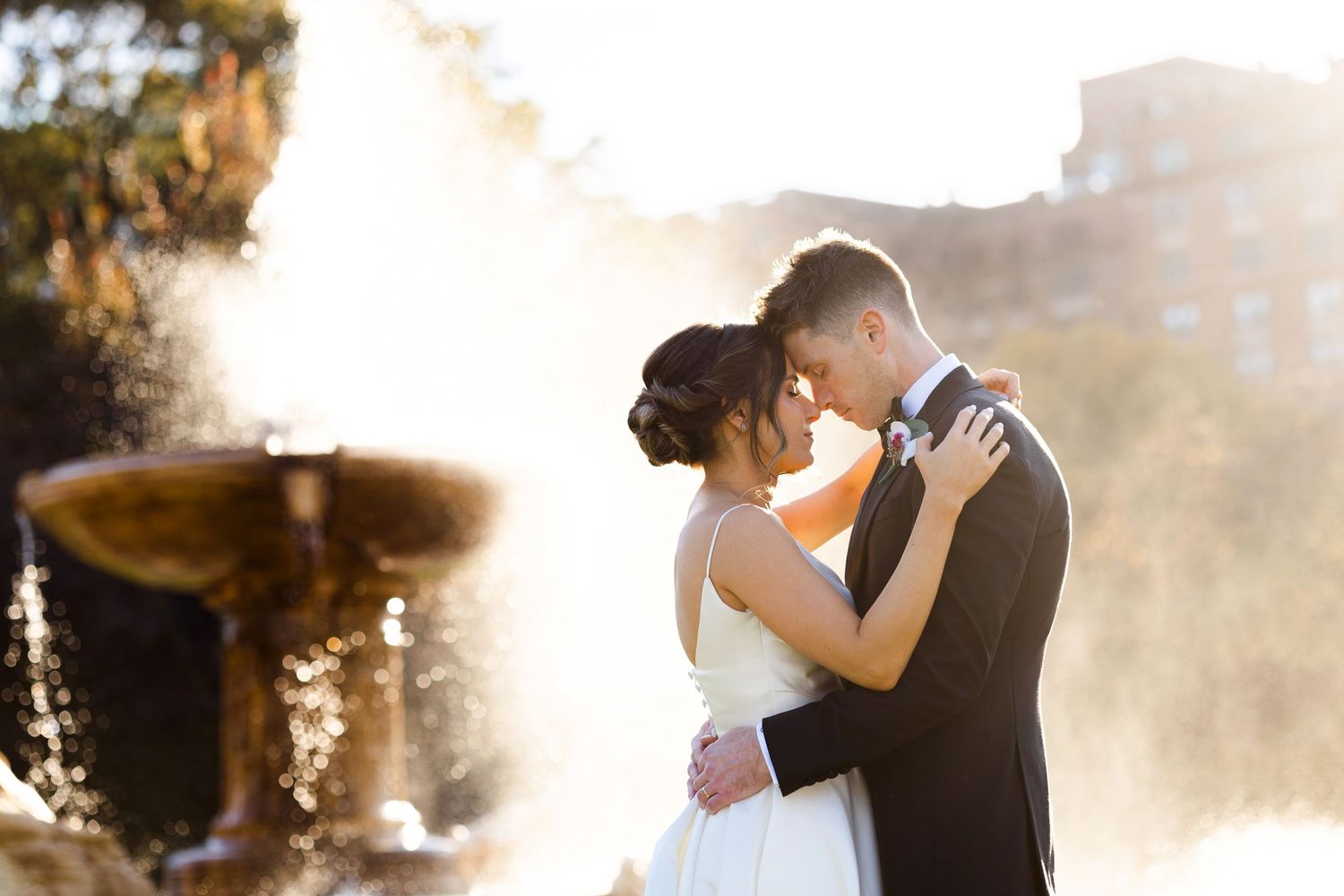 Bride and groom embrace in front of fountain at Cleveland Museum of Art photographed by Tom Forrest.