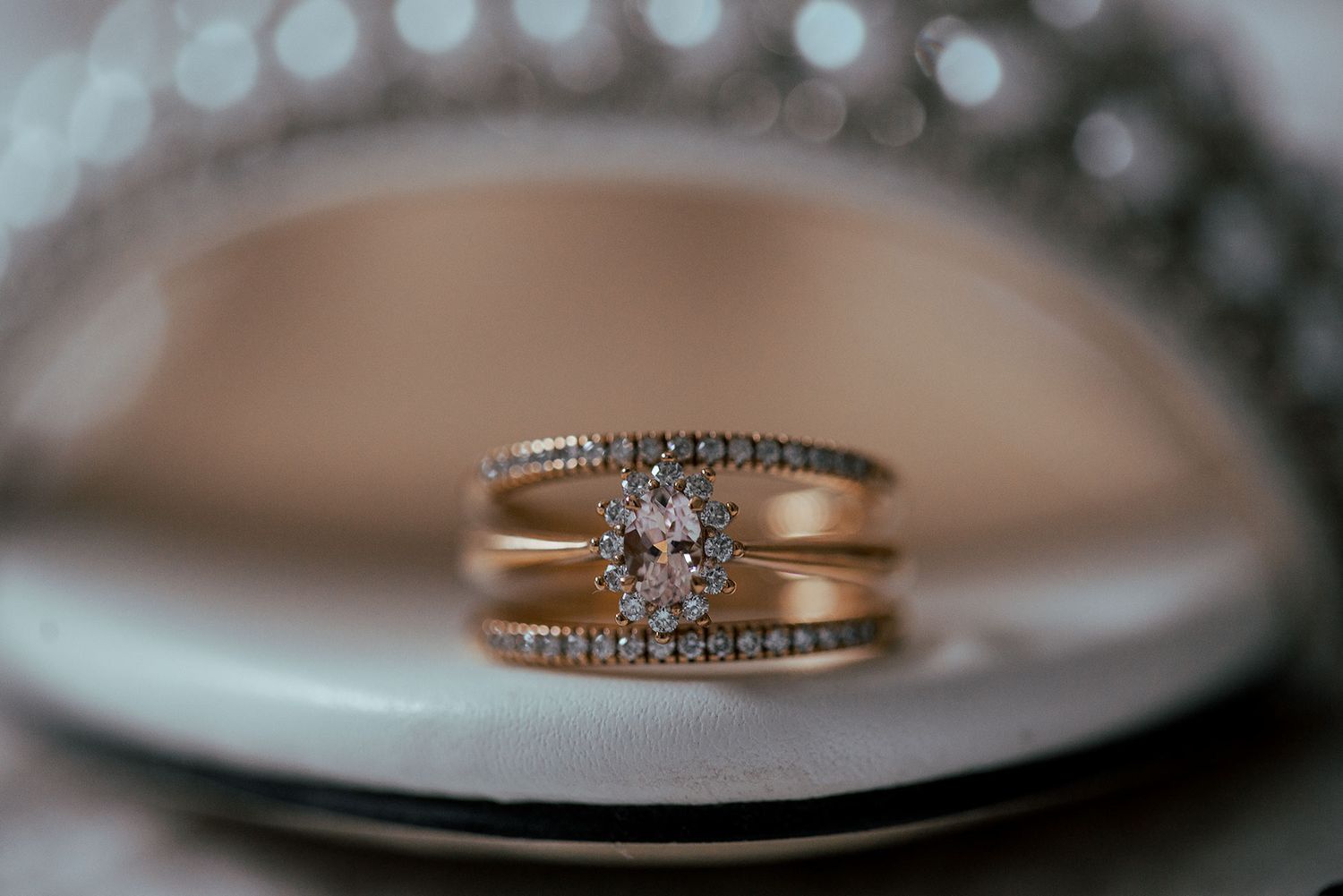 Close-up of an elegant diamond wedding ring set on reflective surface.