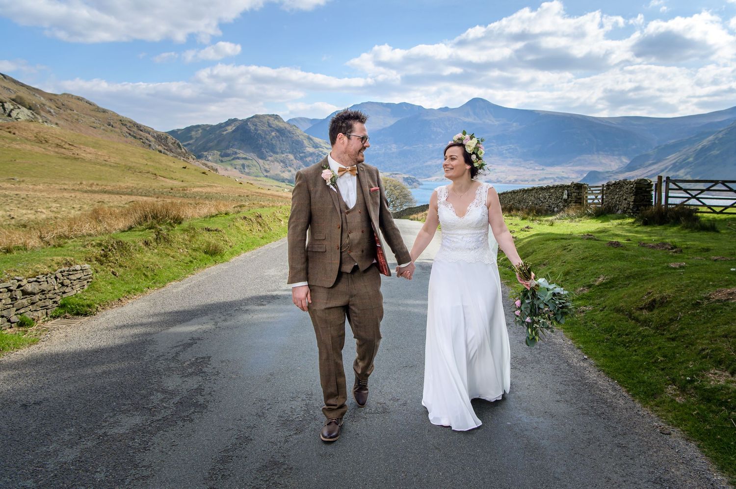 Bride and groom walking down road in Lake District
