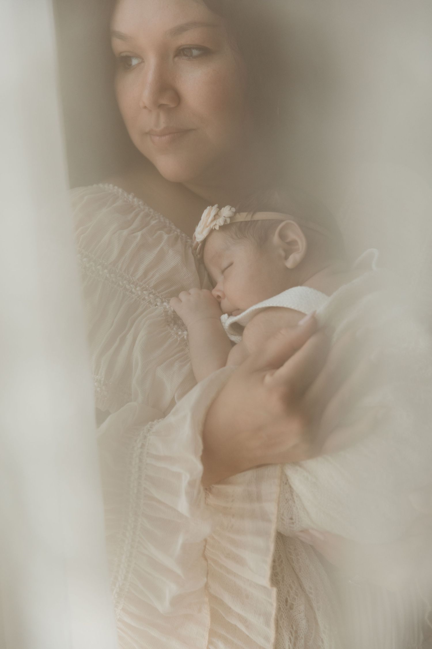 Newborn Baby sleeping peacefully against her mother's chest during a soft, intimate motherhood photography session in Tyler Tx