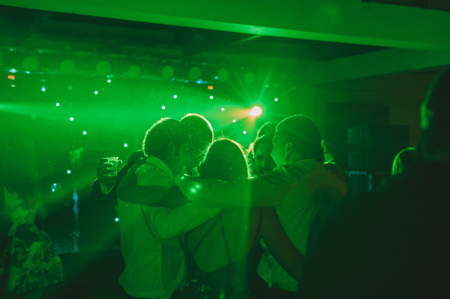 Wedding guests hugging on the dancefloor.