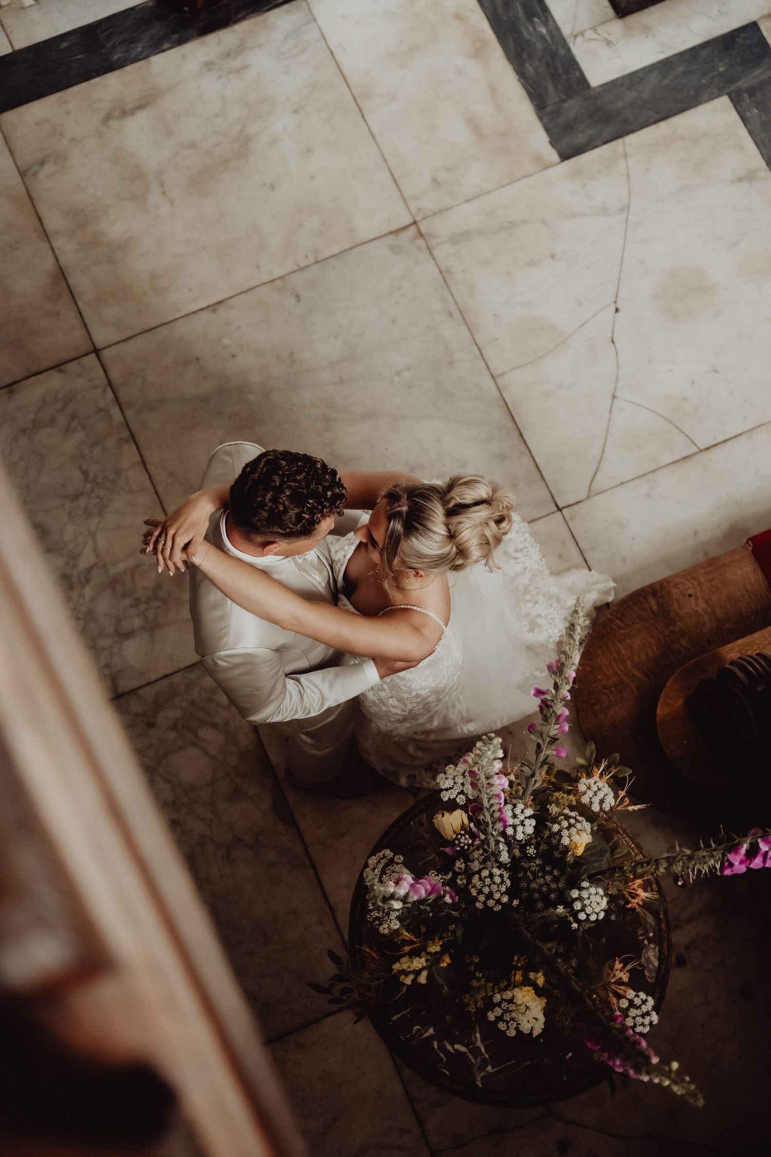Overhead view of a couple dancing with floral arrangements in the foreground.