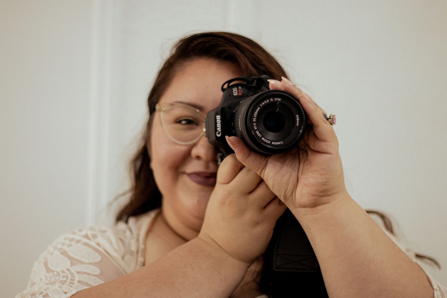 A DSLR camera captures someone taking a series of close-up self portraits in neutral lighting.