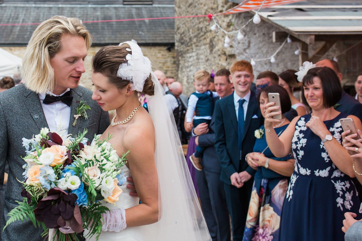 An intimate moment between newlyweds as guests look on at an outdoor wedding in Nova Scotia
