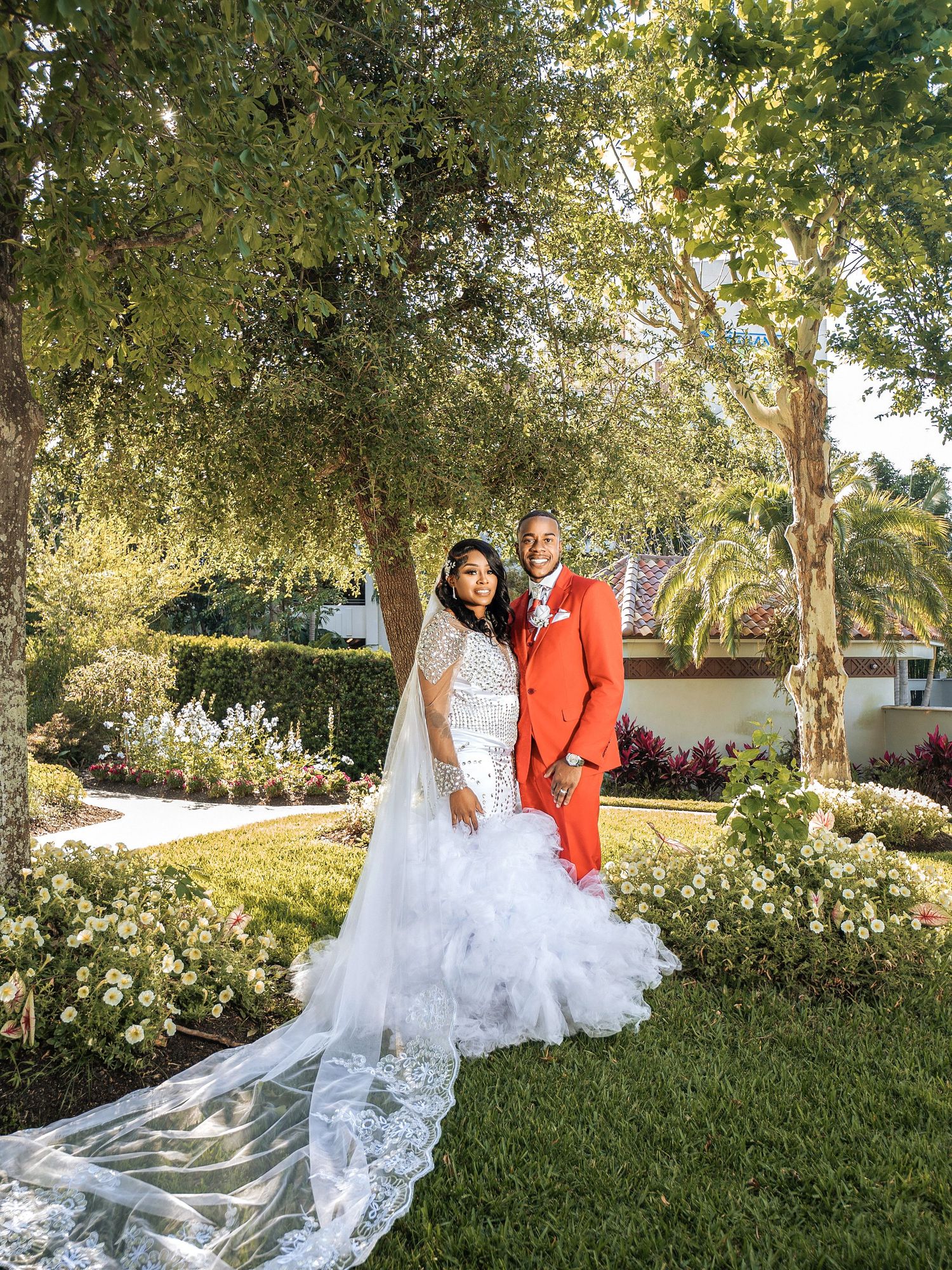 A joyful couple embraces and laughs together while sitting outdoors against a bright blue sky.