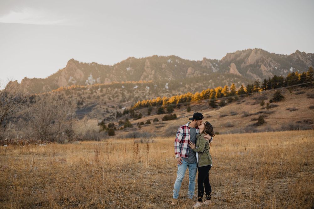 Couple watching sunset together against dramatic mountain backdrop in Colorado.