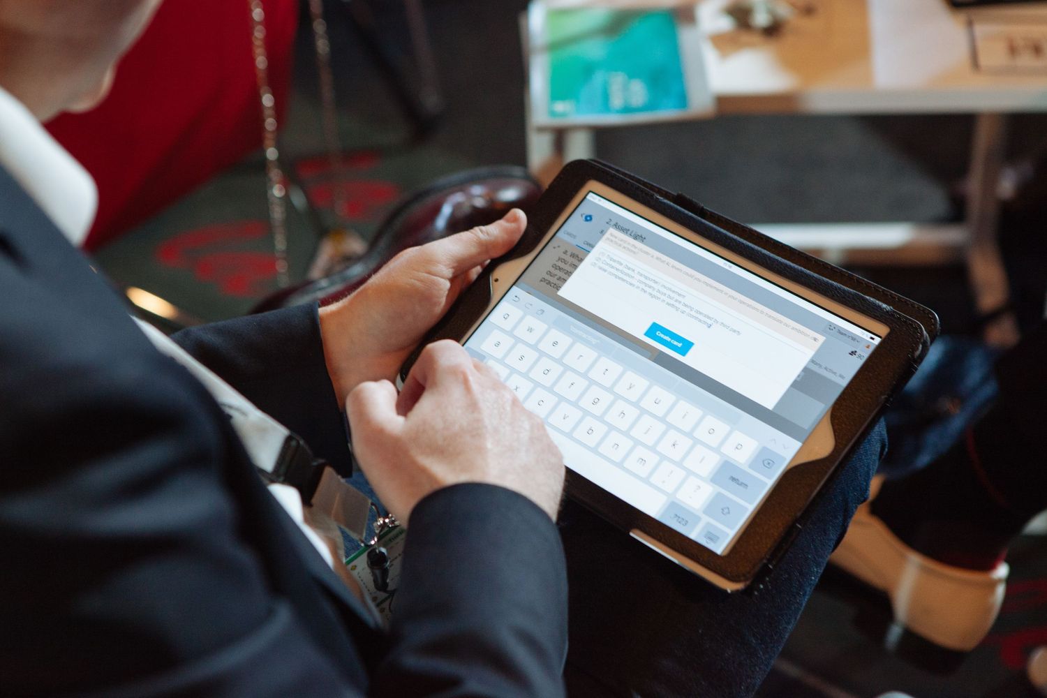 Person using mobile phone to check social media on multiple devices while sitting at desk.