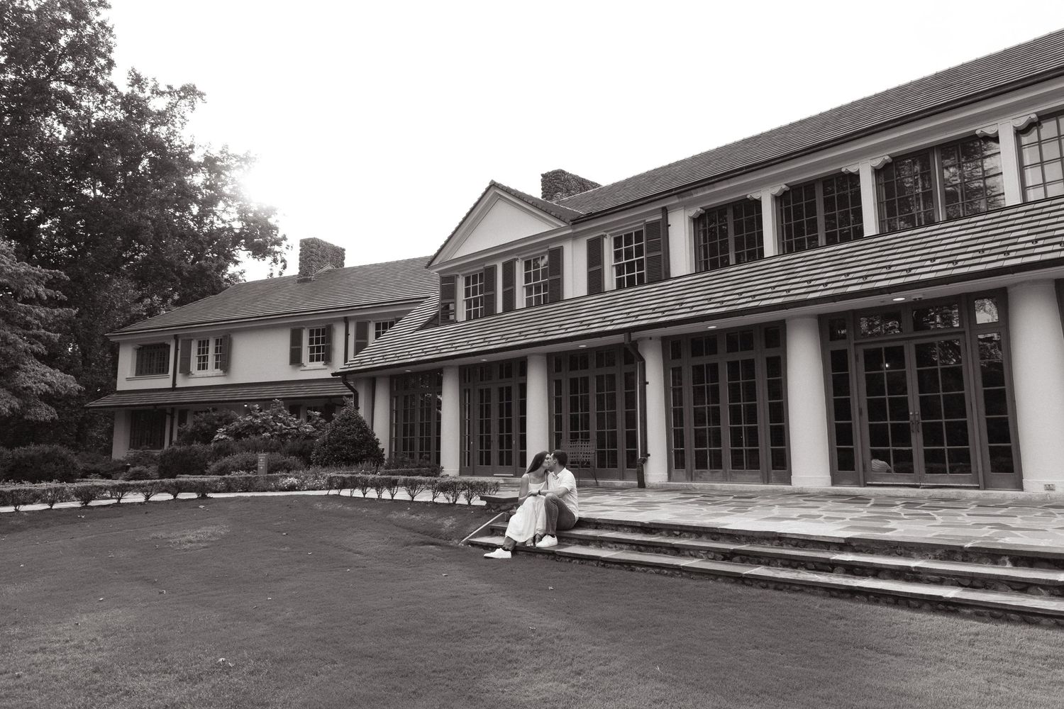 Black and white photo of a colonial style house with steps and columns.