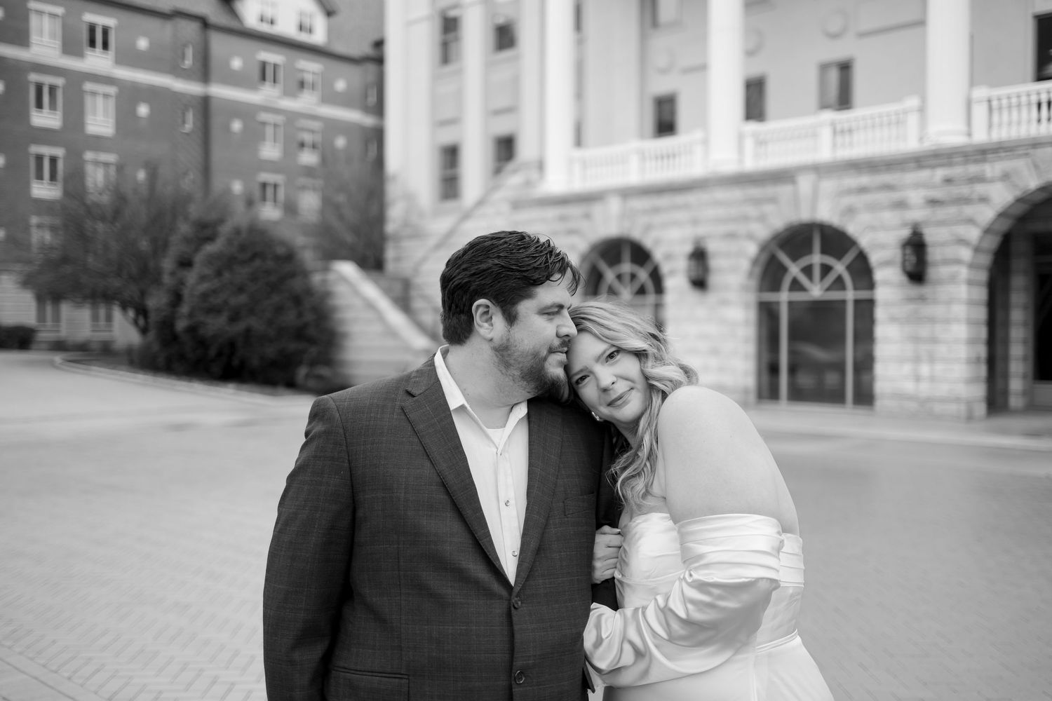 A series of black and white wedding photos showing intimate moments between a couple at an elegant venue.